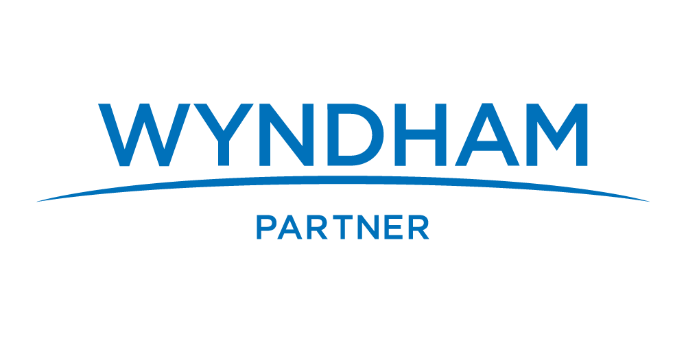 Wyndham Partner · lockup oficial One Trade × Wyndham Hotels & Resorts